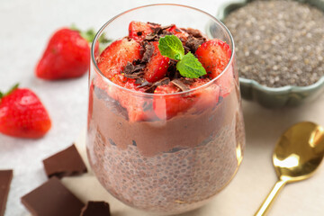 Delicious chocolate pudding with chia seeds, strawberries and mint on table, closeup