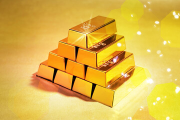 Stacked shiny gold bars on color background