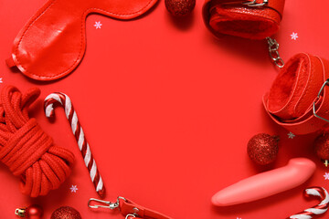 Frame made of different sex toys with Christmas balls and candy canes on red background