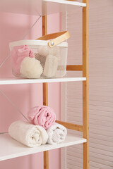 Shelving unit with towels in interior of stylish bathroom, closeup
