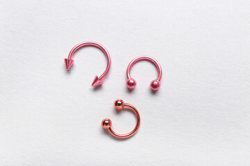 Colorful circular barbells for piercing on white background