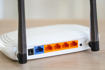 Modern wi-fi router on desk in office, closeup