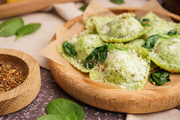 Plate of tasty ravioli with cheese on grey background