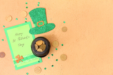 Leprechaun pot with golden coins, paper hat and card on beige background. St. Patrick's Day...