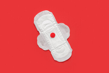 Menstrual pad with paper blood drop on red background