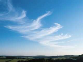 Blue Sky with Unique Cloud Formations Over Green Landscape