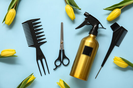 Hairdresser's tools with beautiful yellow tulips on blue background