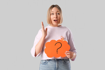 Shocked mature woman with ribbon and speech bubble on grey background. Multiple Sclerosis Awareness...