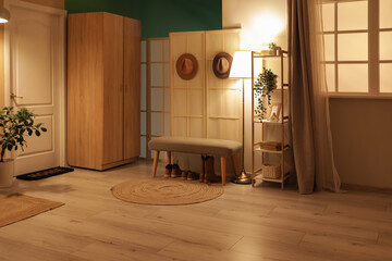 Shelving unit, bench and glowing lamps in interior of hallway