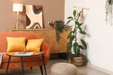 Interior of stylish room with orange sofa, coffee table and houseplant
