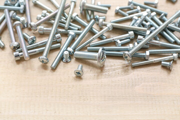 Different tap bolts on wooden background, closeup
