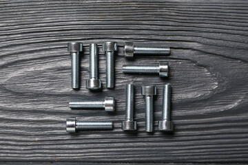 Tap bolts on grey wooden background, closeup