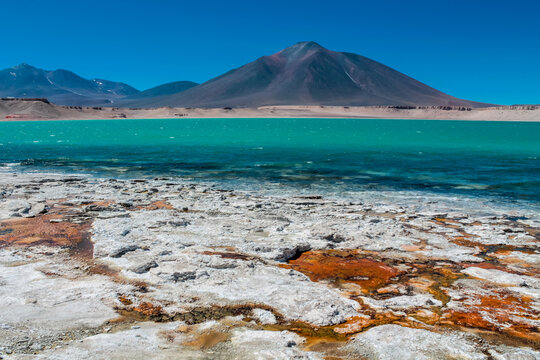Laguna Verde green lake in Atacama desert, Chile. Base camp for ascent on the volcano Ojos del Salado in chilean desert. Arid land and soil on the shore of a lake with vibrant green surface. Atacama