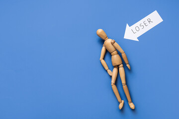 Arrow with word LOSER and wooden mannequin on blue background