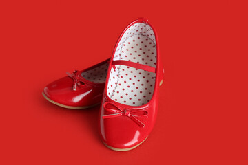 Cute girl's shoes on red background