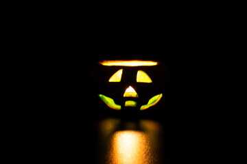 Ceramic candle holder in the shape of a halloween pumpkin. Candle lit in a Jack O Lantern

