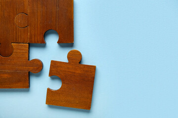 Wooden puzzle pieces on blue background. Logic concept
