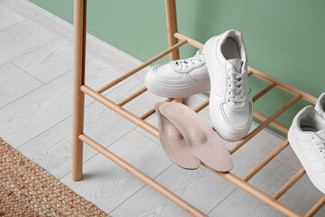 Sneakers with orthopedic insoles on stand in hallway