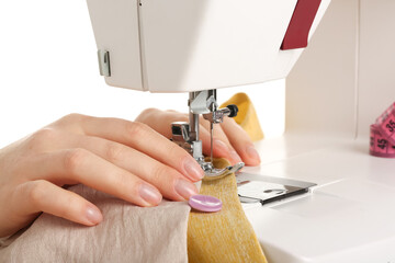 Female hands sewing clothes on white background, closeup