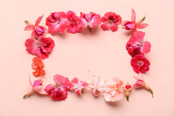 Frame made of different beautiful edible flowers on pink background
