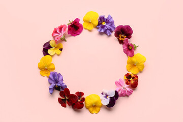 Frame made of different beautiful edible flowers on pink background