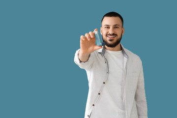 Young man with inhaler on blue background