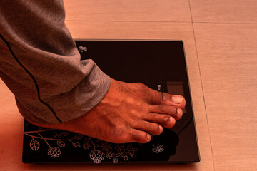 Young woman checking body weight on digital scale at home for healthy lifestyle