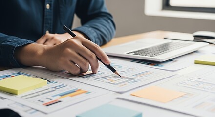 Focused Designer Reviewing UI Mockups on a Desk