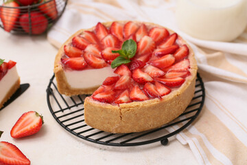 Stand of cut sweet strawberry tart with mint on white background, closeup