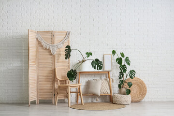 Interior of living room with Monstera plants, table and chair