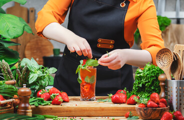 Creating a vibrant vegan nojito beverage with fresh ingredients in a cozy kitchen