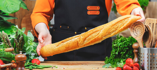 skilled chef focuses on healthy cooking using fresh baguette bread, vegetables and healthy ingredients, showcasing passion for vegan lifestyle in kitchen.