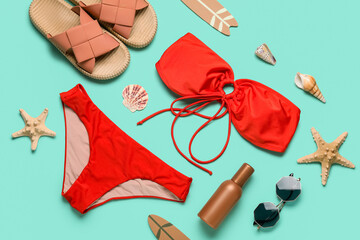Composition with swimsuit, tropical leaves and beach accessories on turquoise background
