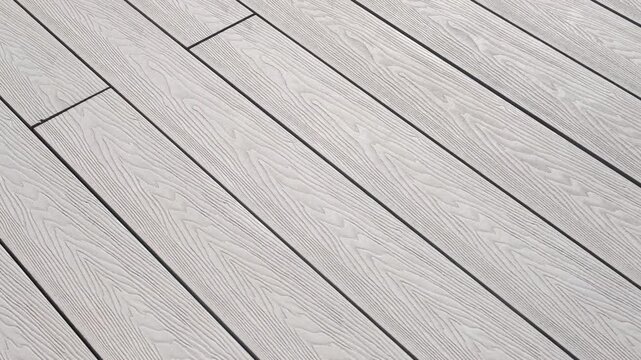 Close-up of light gray composite decking with pronounced wood texture. The surface appears modern and neat, perfect for outdoor relaxation areas and stylish architectural solutions
