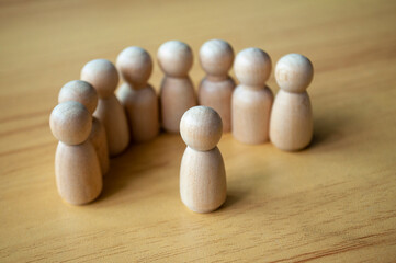 A Figure Facing Beige Pegs In Formation On Wood Surface