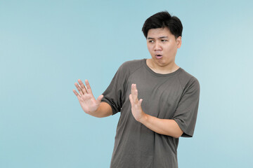 young asian man showing refusing gesture in studio background