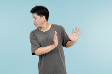 young asian man showing refusing gesture in studio background