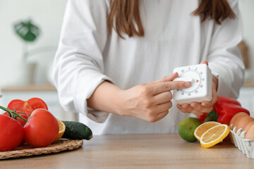Woman with modern kitchen timer at table in room, closeup