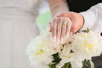 Newlyweds with ring and flowers on their wedding day, closeup