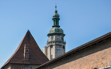 Tall, historic clock tower of the St. Andrew's Church in Lviv with a green dome and cross stands...