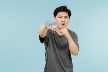 young asian man in fighting stance in studio background
