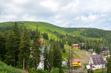 Picturesque mountain Dragobrat ski resort nestled among lush forests, featuring charming houses and...