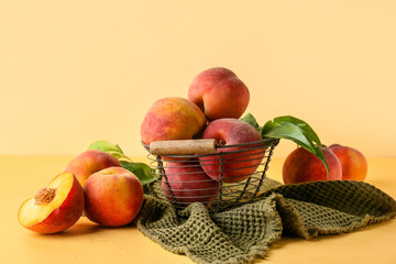 Basket of fresh peaches on yellow background