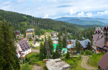 Picturesque mountain Dragobrat ski resort nestled among lush forests, featuring charming houses and...