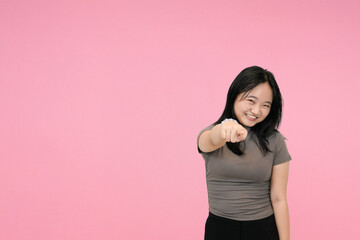 short asian woman pointing at you that you are the choosen one in pink studio background