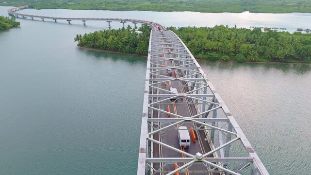 Aerial tracking shot flying over the San Juanico Bridge in the Philippines. Follows the flow of vehicles crossing between Leyte and Samar.