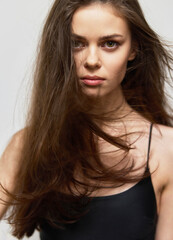 Confident young woman with long hair, looking directly at the camera with a strong expression....