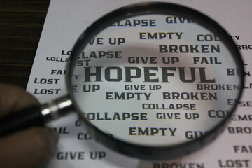 Magnifying glass highlighting the word 'HOPEFUL' among negative words like give up, lost, and...