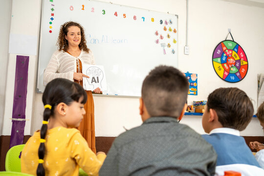 Preschool teacher shows kids illustrated cards of a brain and AI head with gears, sparking a fun discussion about how humans and machines think differently
