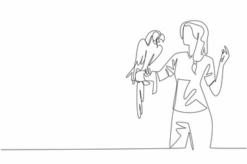 Single one line drawing blue gold macaw parrot perched on hand of woman. Large parrot with long tail feathers. Grain eaters. Pets. Woman Holding Bird. Continuous line design graphic illustration